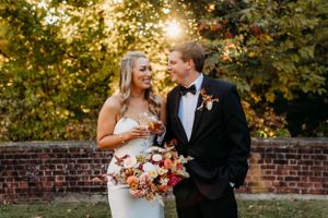 Portrait of a bride and groom holding champagne glasses in golden light at the Peterloon Estate in Cincinnati.