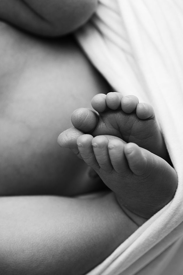 Black and white image focused on newborn baby girl's toes.