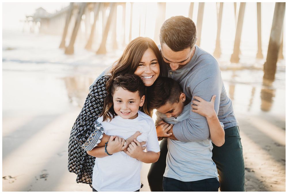 family hugging on beach