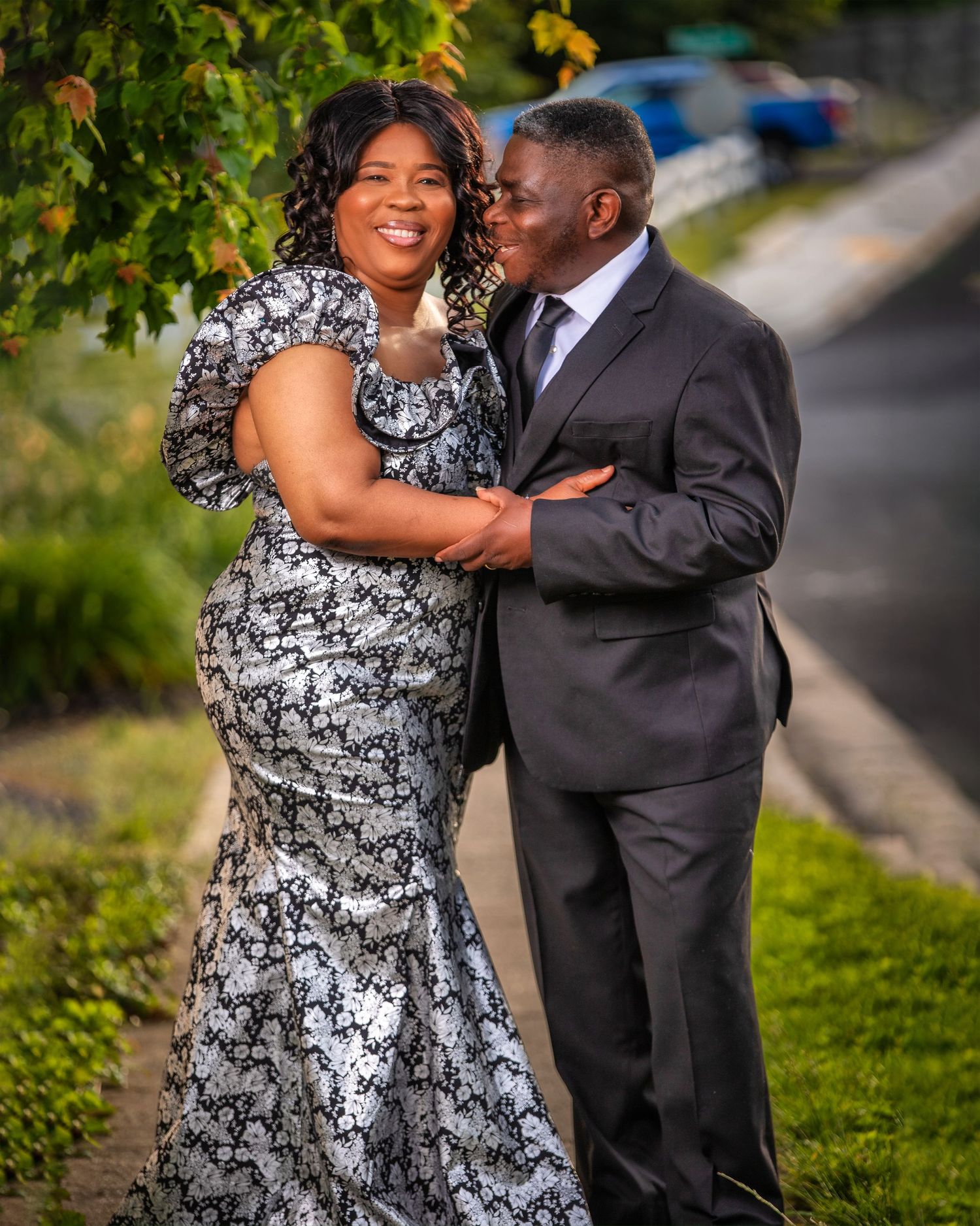 Outdoor engagement photo session showing couple in formal wear on grassy hillside.