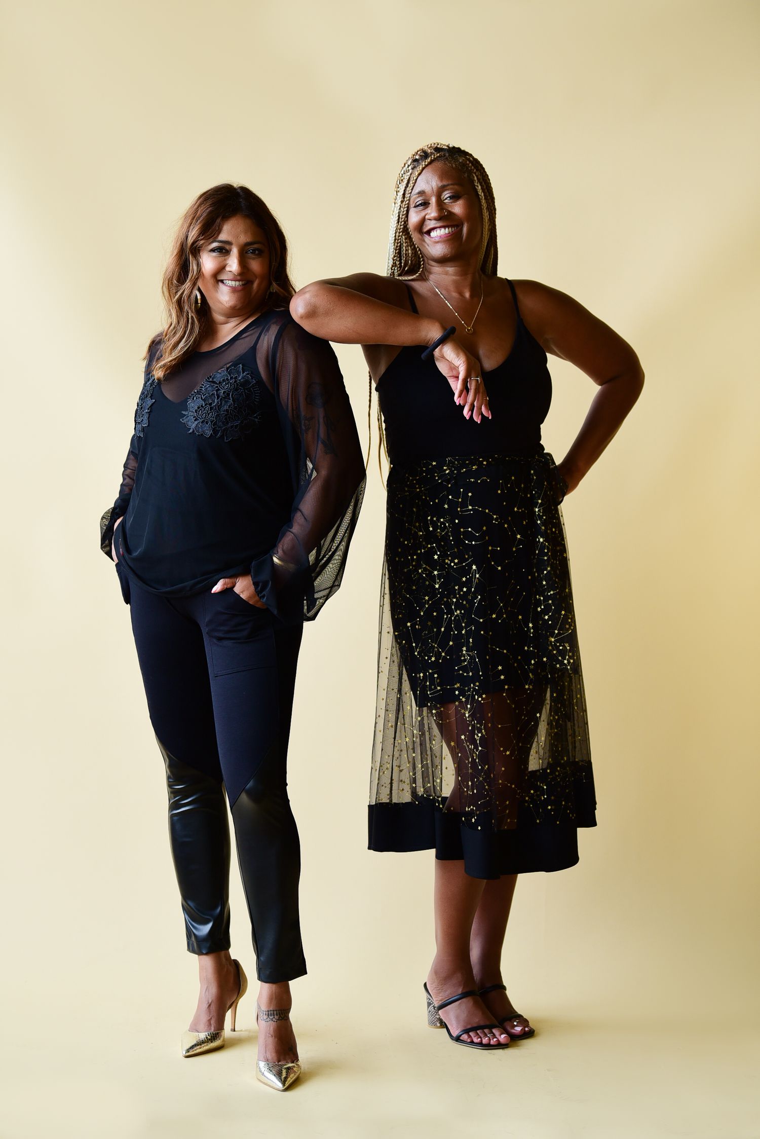 Two models pose in evening wear featuring sheer black details and sparkly embellishments.