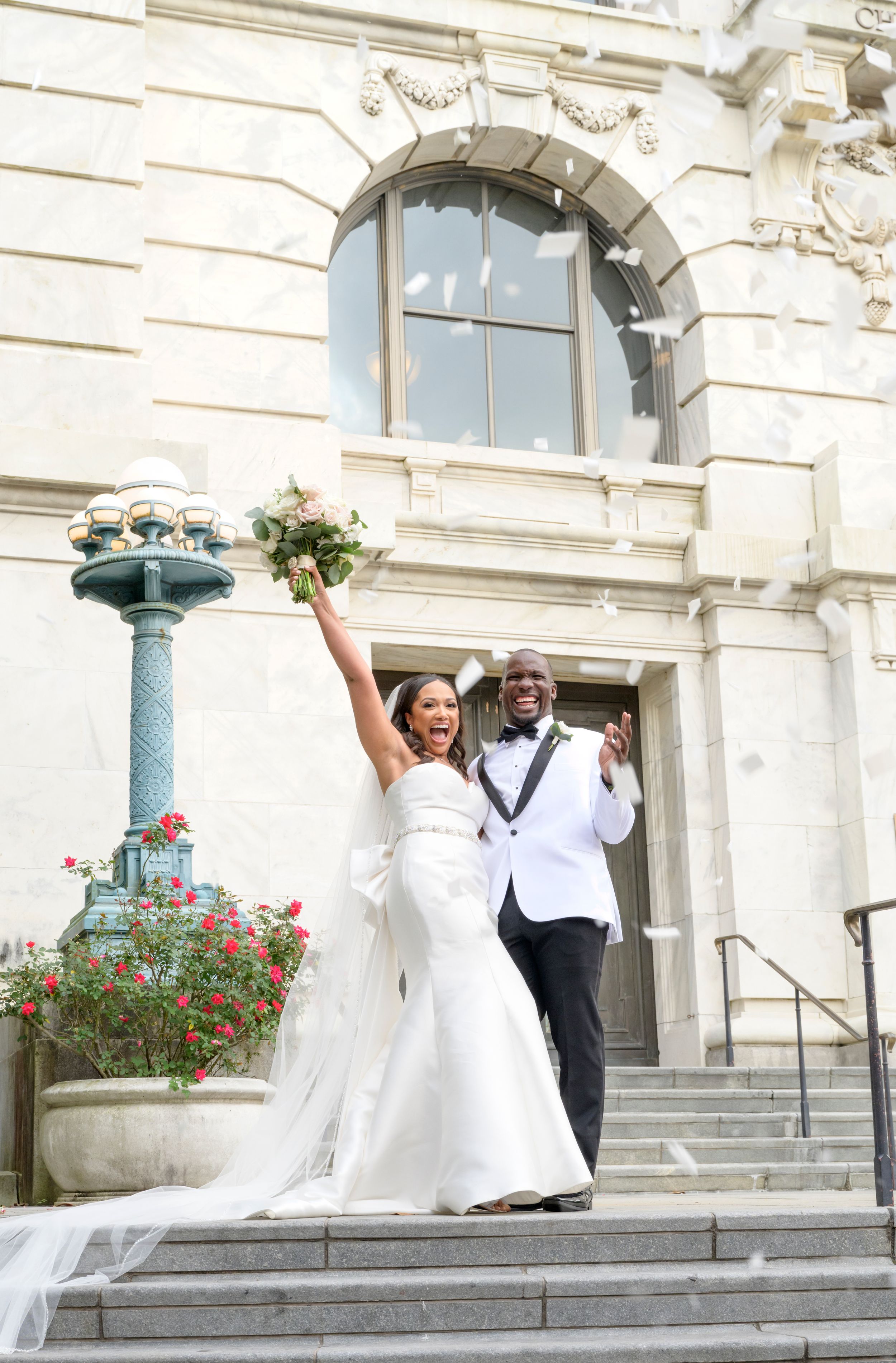 A celebratory moment on grand stone steps with architectural details and flowers.