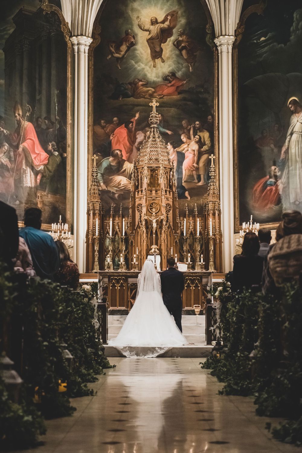 A cathedral wedding ceremony with ornate altar and religious artwork in dramatic lighting.