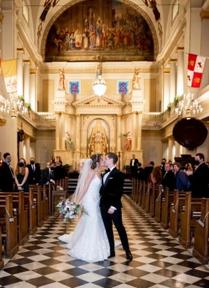 Wedding ceremony in grand historic church with checkered floor and ornate architectural details.