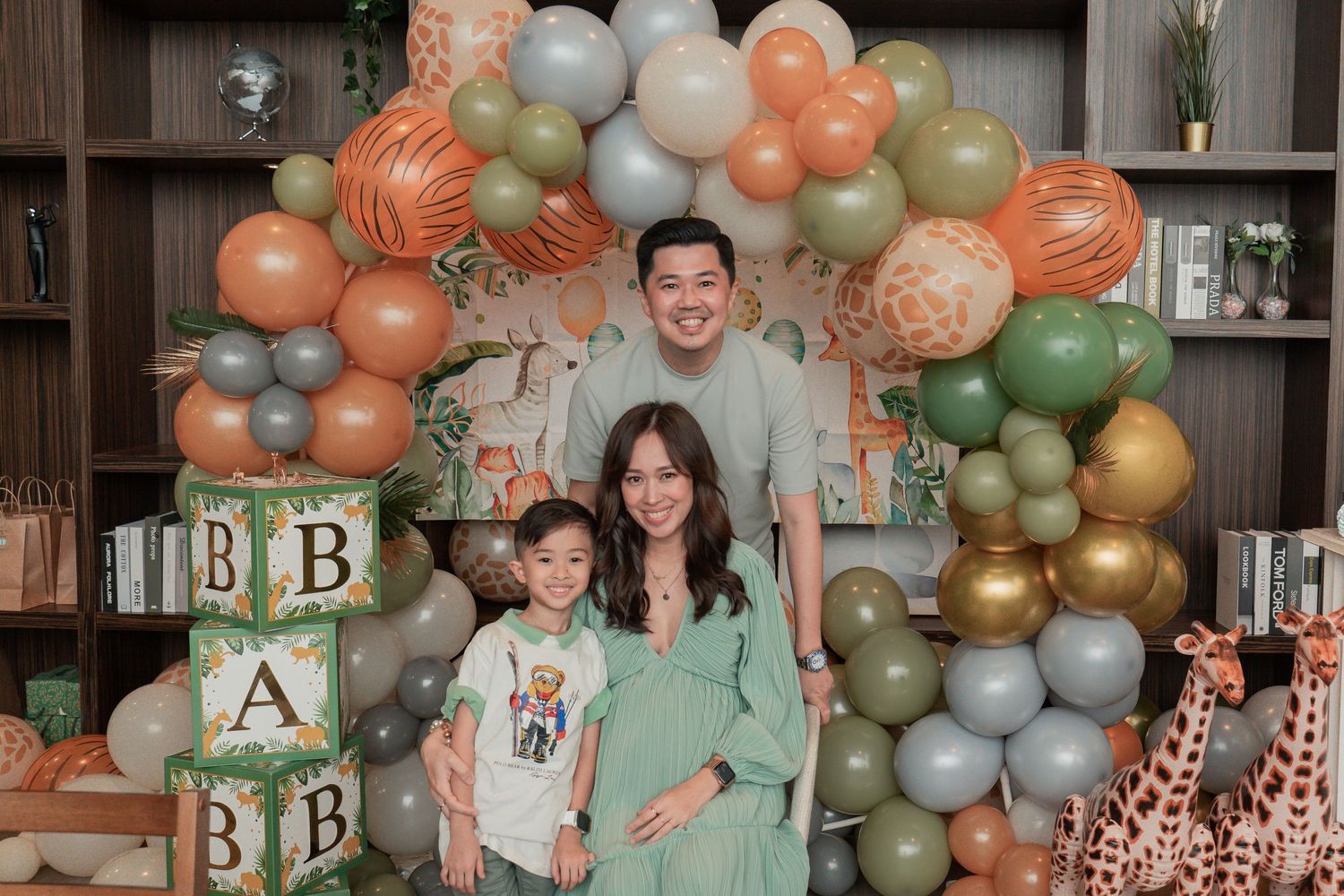 Baby shower celebration with elegant balloon arch and alphabet block decorations in peach and green tones.