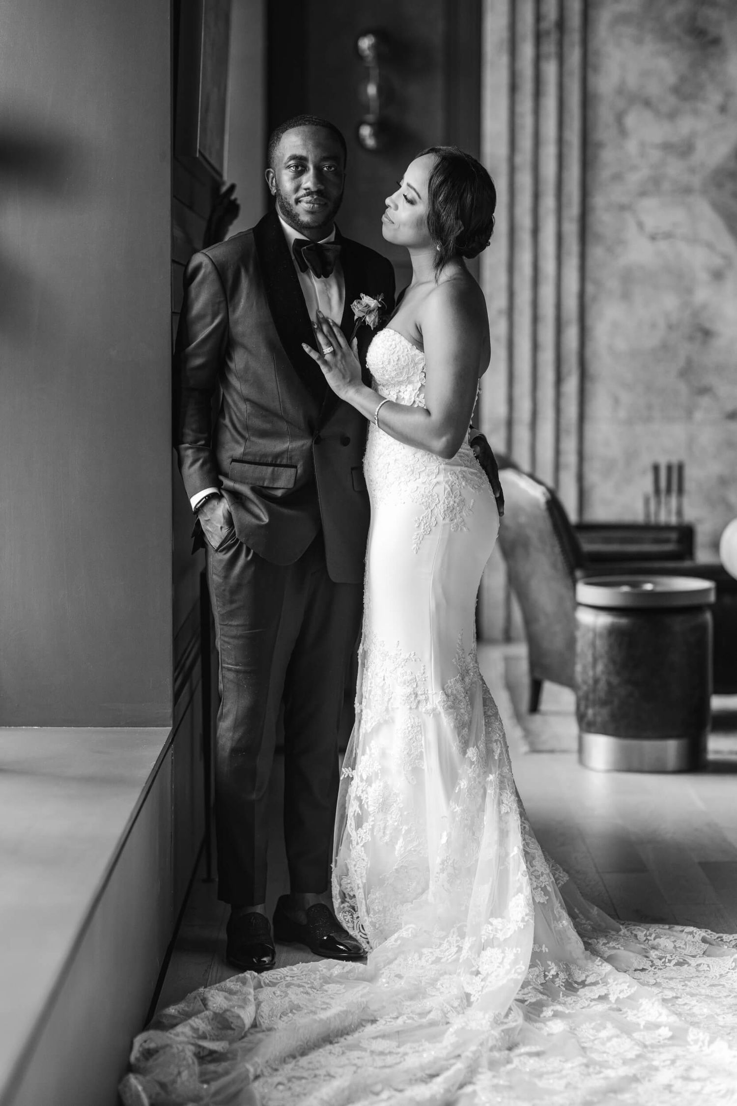 An elegant black and white wedding portrait showing tender interaction between the couple.