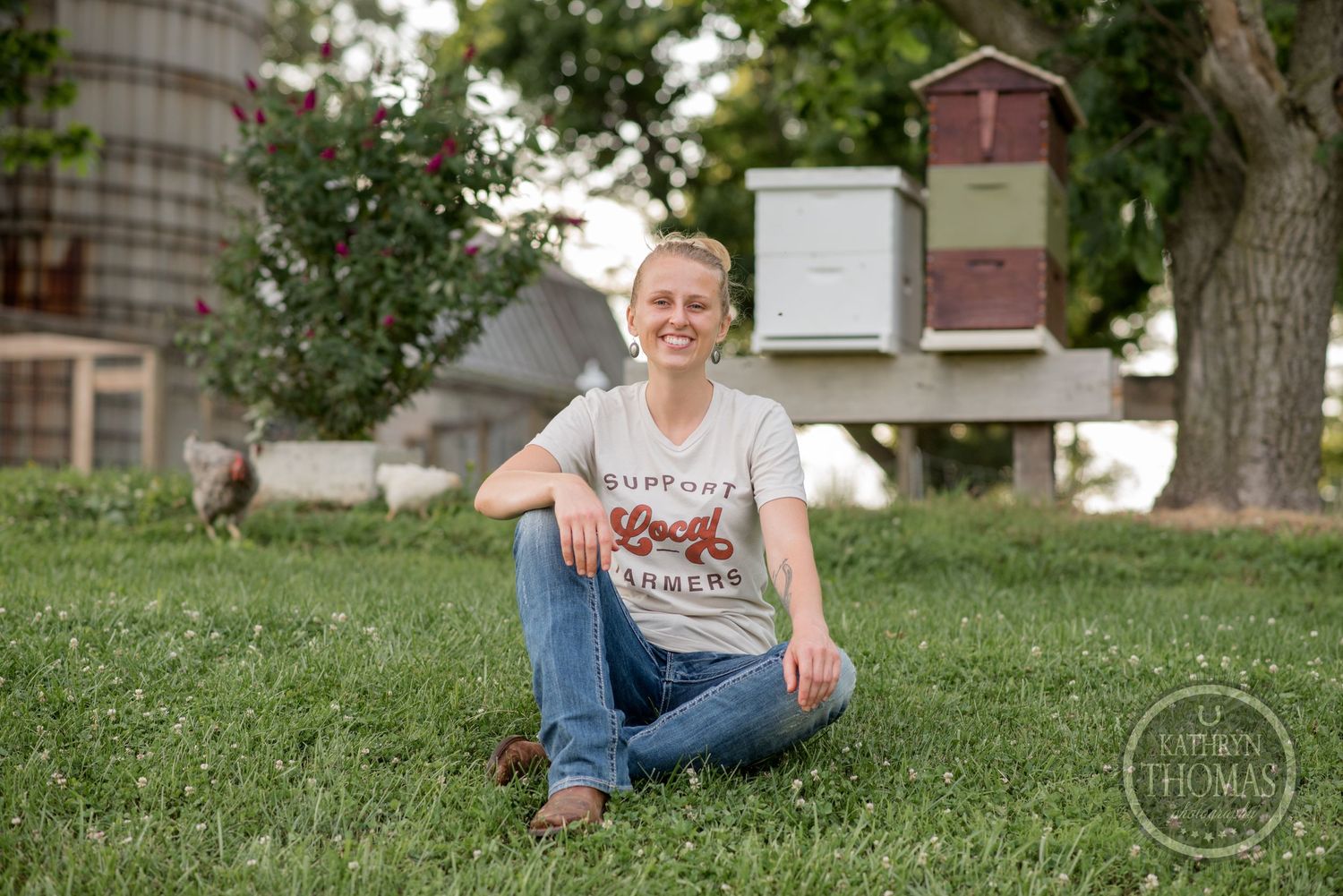 A pastoral scene with beehive boxes and farm buildings visible in the background.