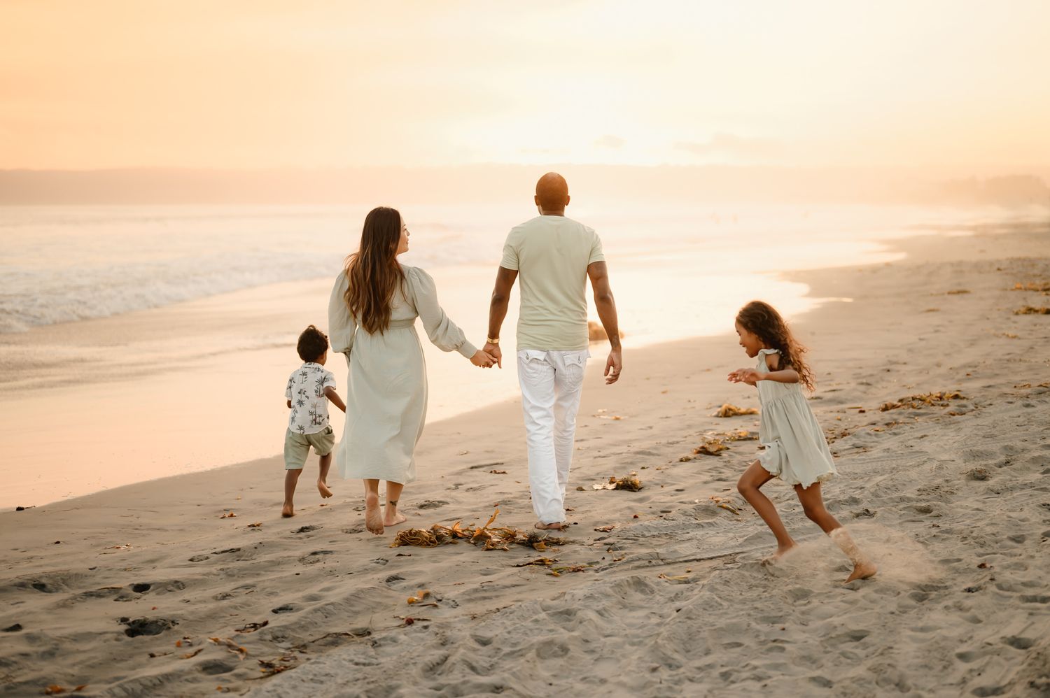 family portrait by best Ventura family photographer, of family walking on sand at Coronado Beach