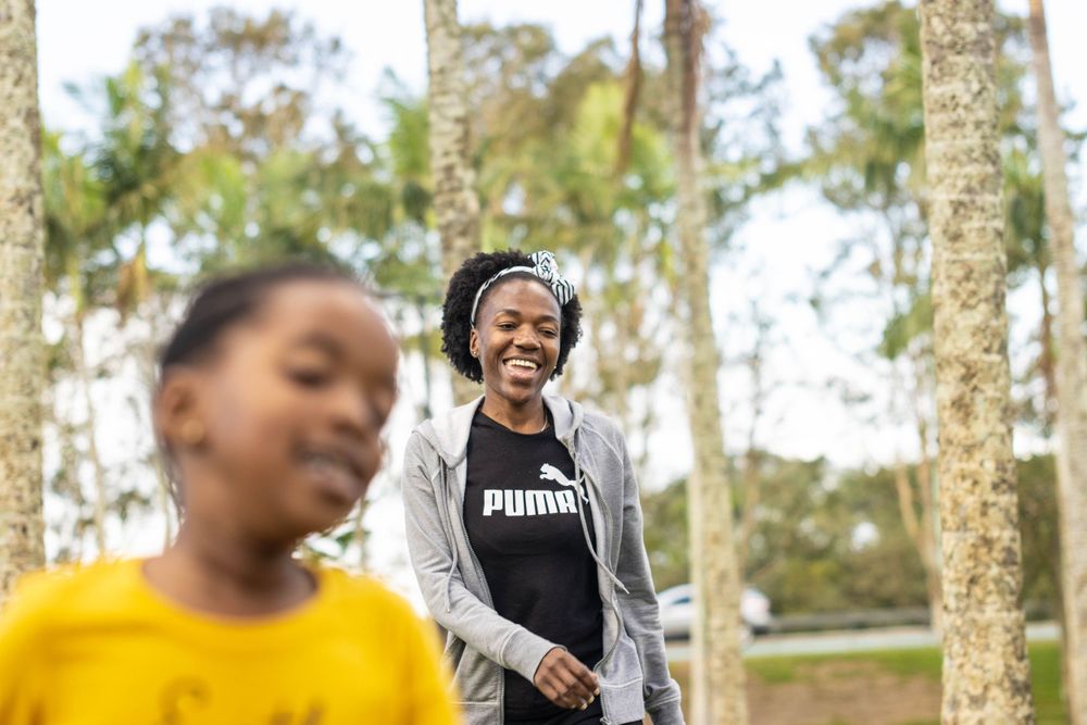 People enjoying outdoor activity among tall trees in a natural park setting.
