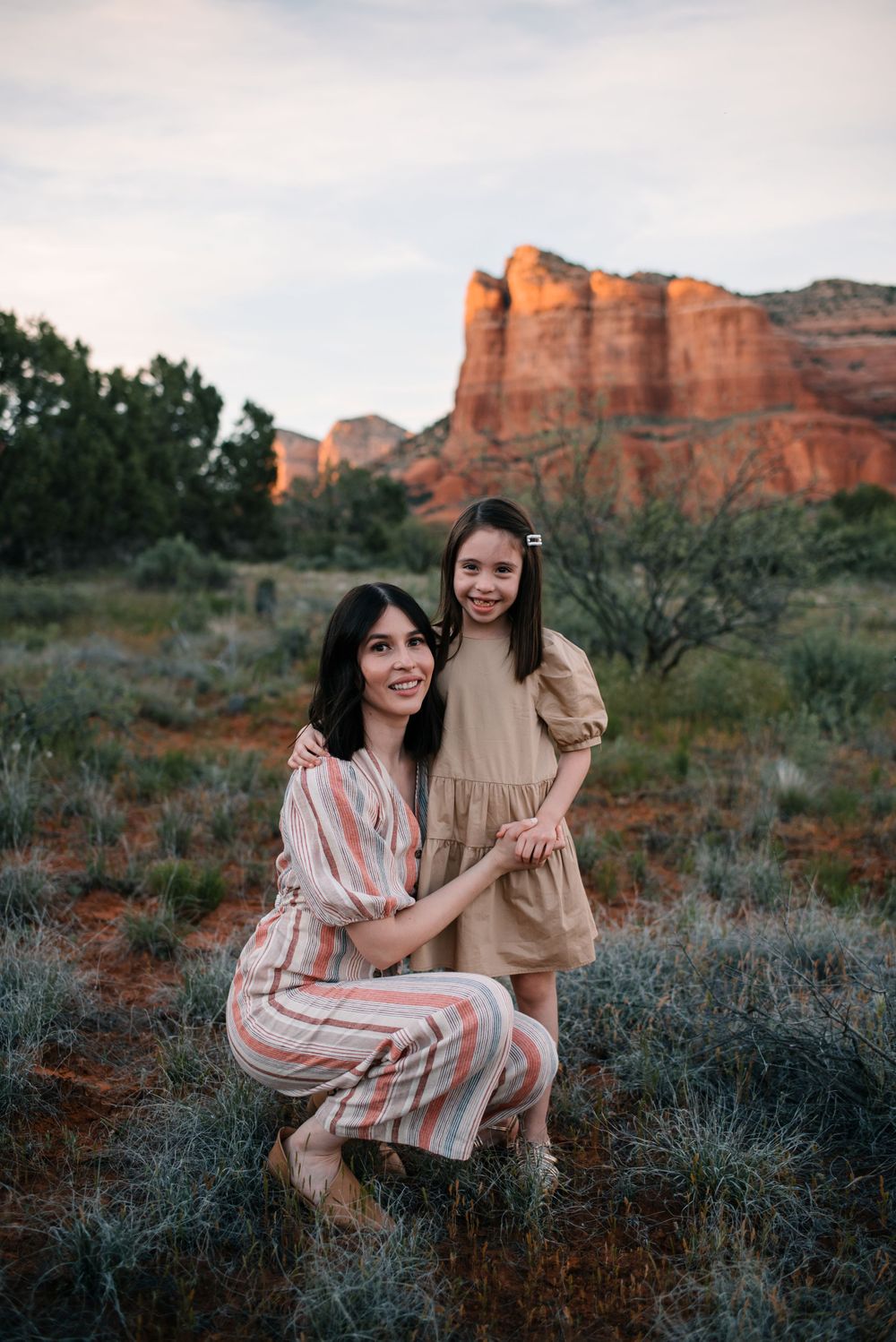Candid family moments captured against beautiful desert rock formations at sunset.