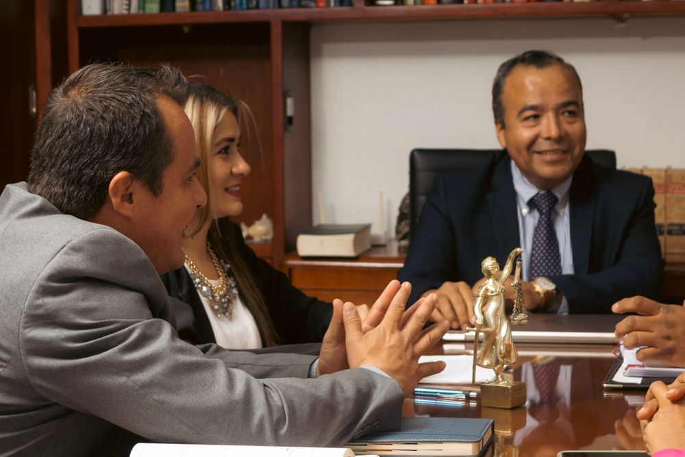 Business professionals engaged in a friendly meeting discussion at an office conference table.