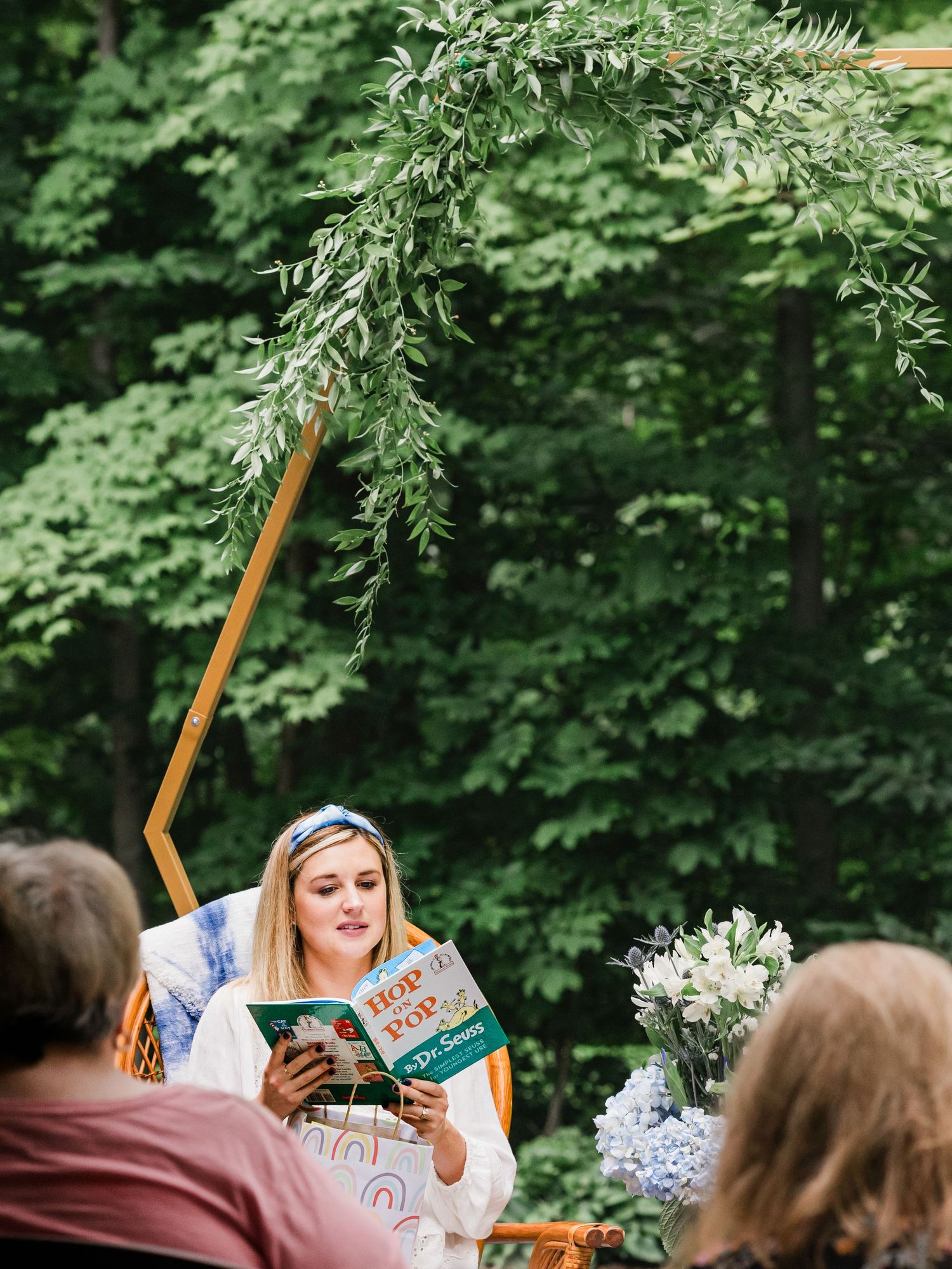 mama to be reading children's book at back yard baby shower