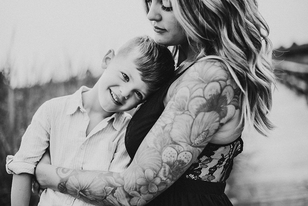 Black and white portrait capturing intimate embrace outdoors.