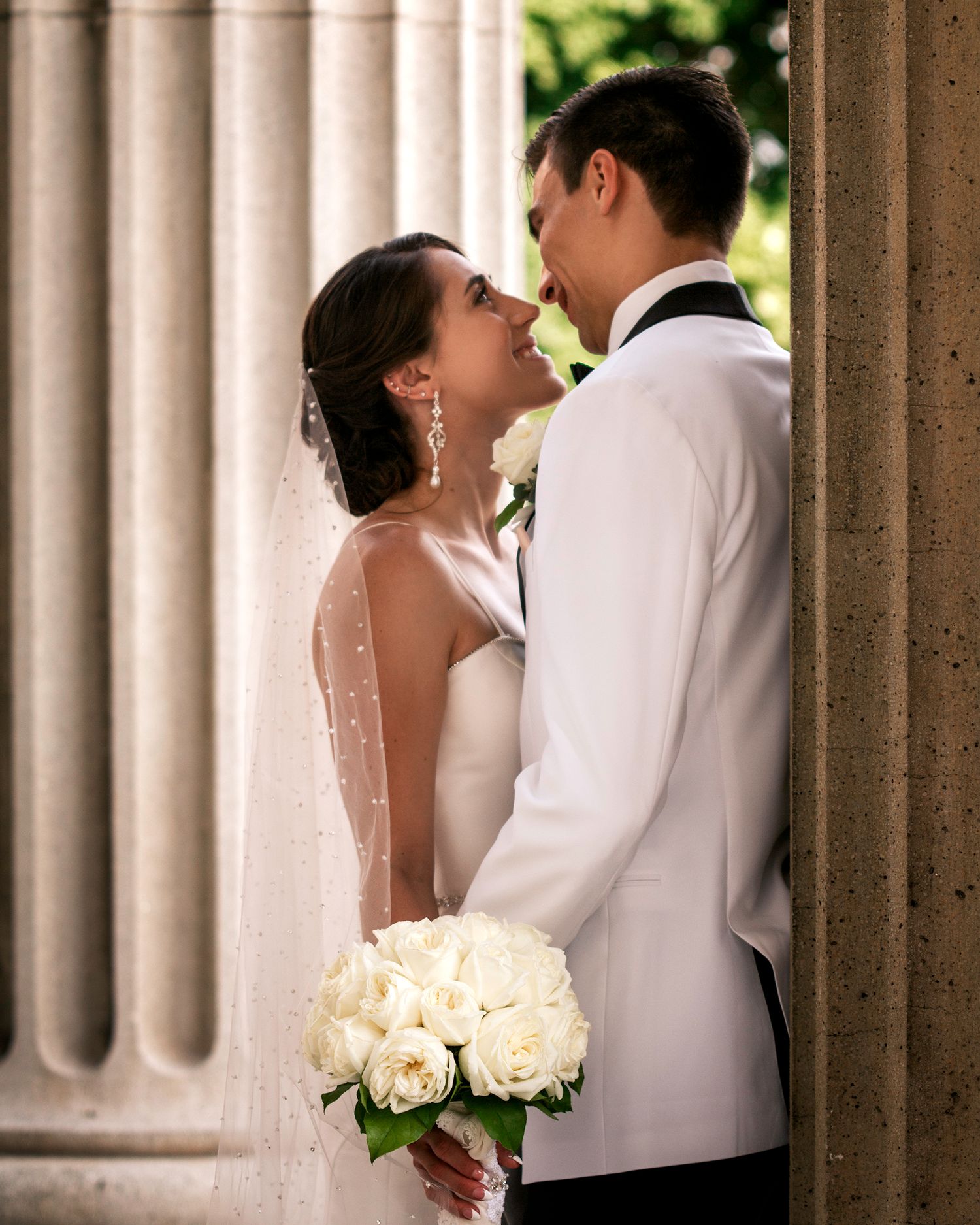 Elegant wedding photography series featuring classic white columns and formal attire.