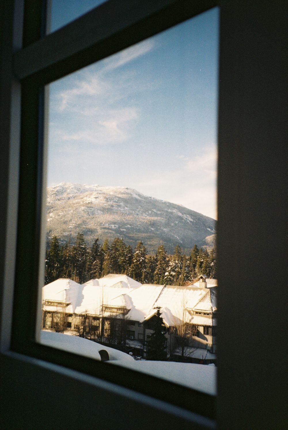 Snowy mountain landscape viewed through a window frame.
