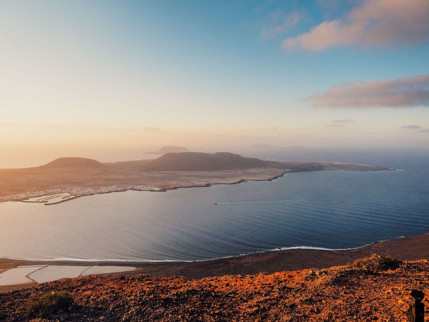 Scenic coastal landscape view of mountains and ocean during golden sunset.