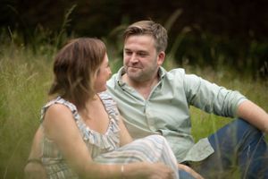 couple in long grass at pre wedding engagement photoshoot