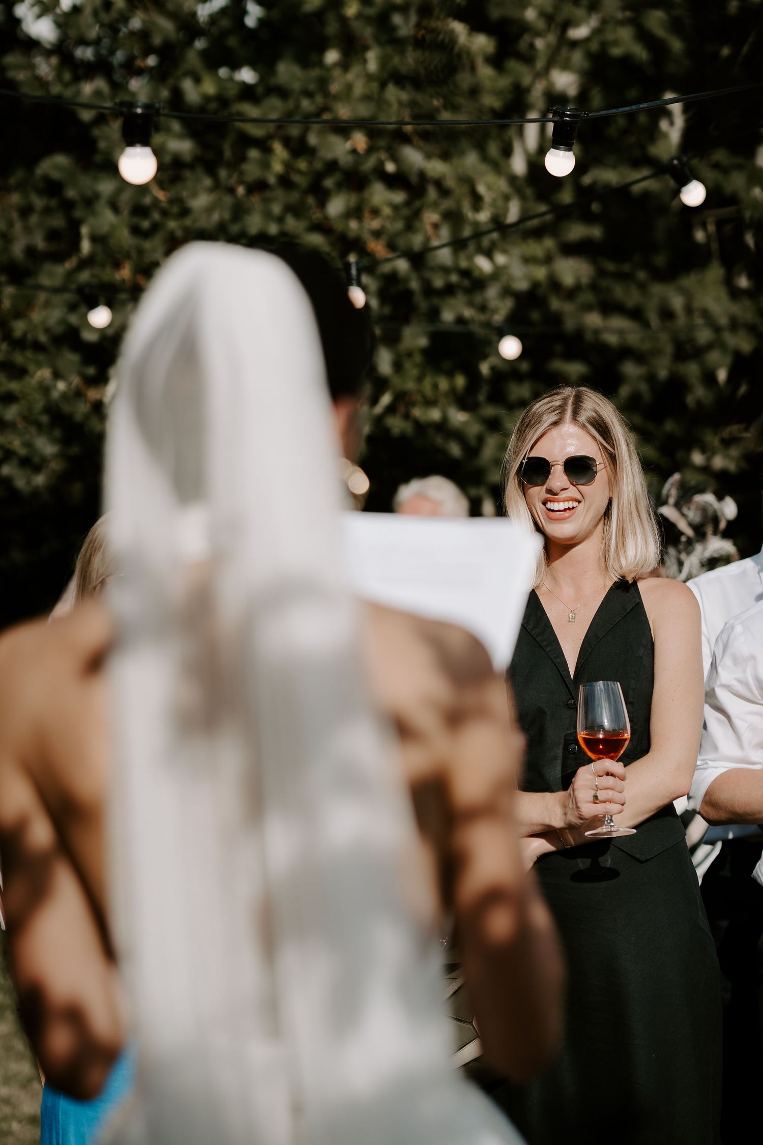 wedding guest smiling at bride as she gives her speech at marquee wedding in islip in Oxfordshire