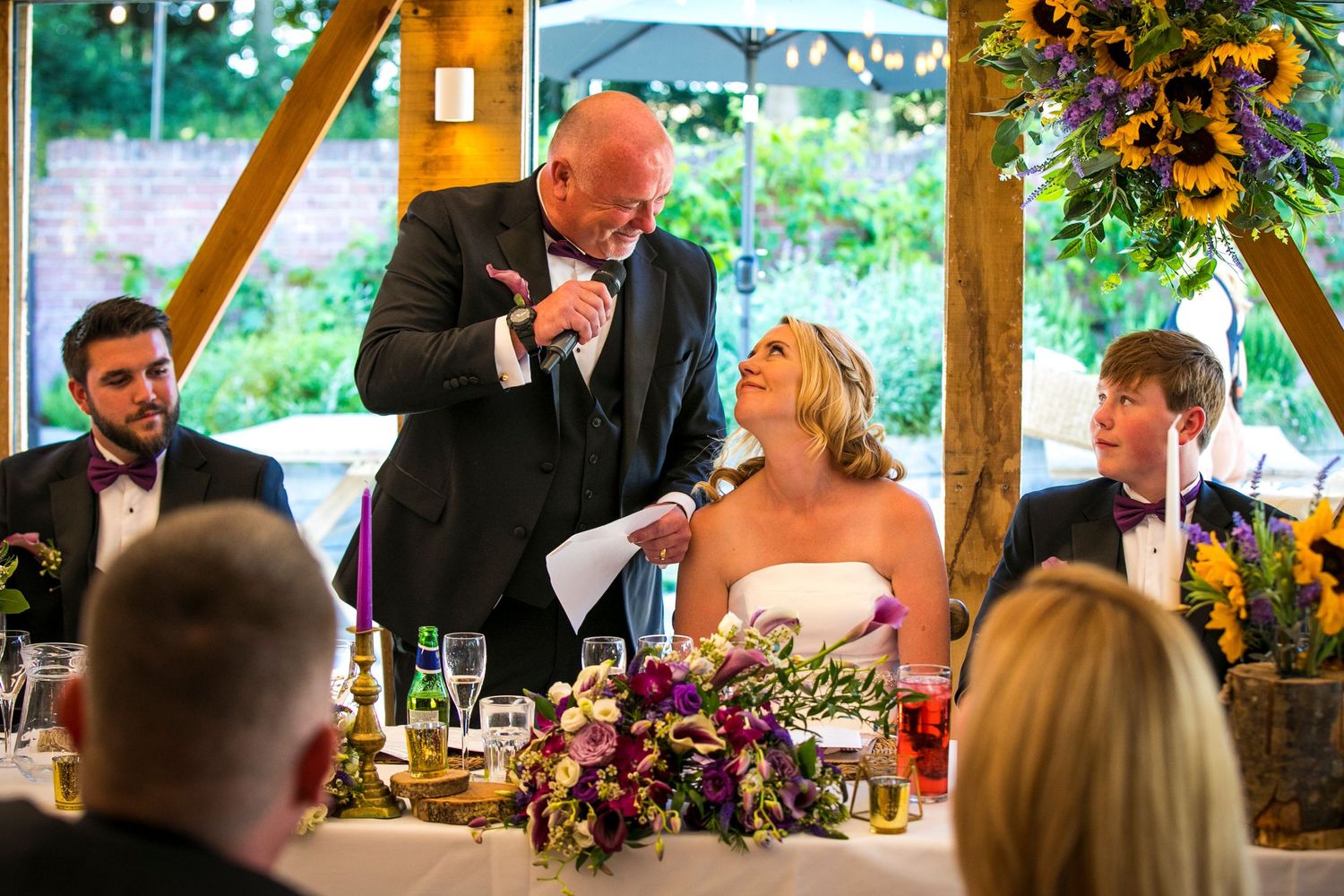Wedding guests enjoying a festive reception with colorful floral decorations and bunting.