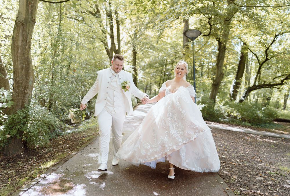 Playful wedding photos of couple on wooded trail surrounded by greenery.