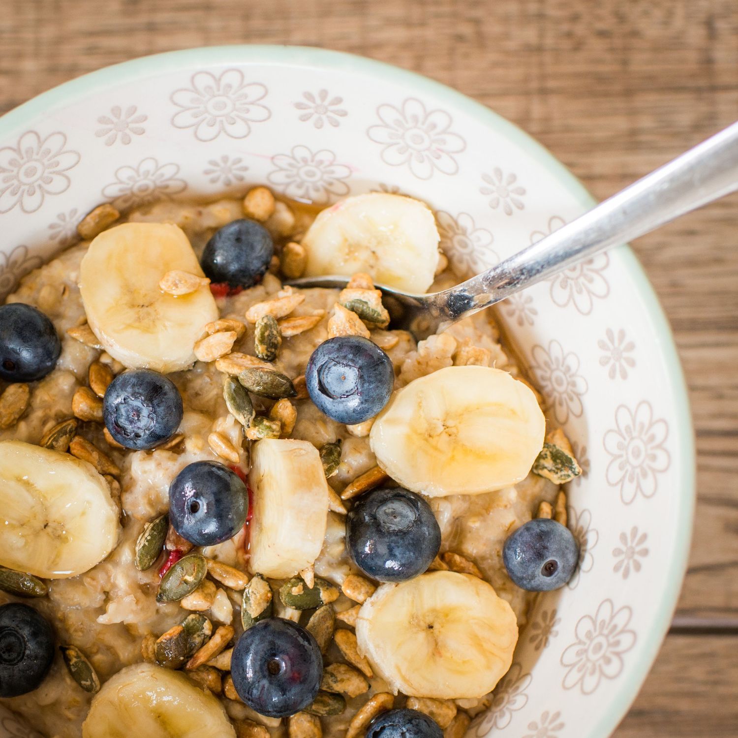 close up image of a bowl of porridge with banana and blueberries