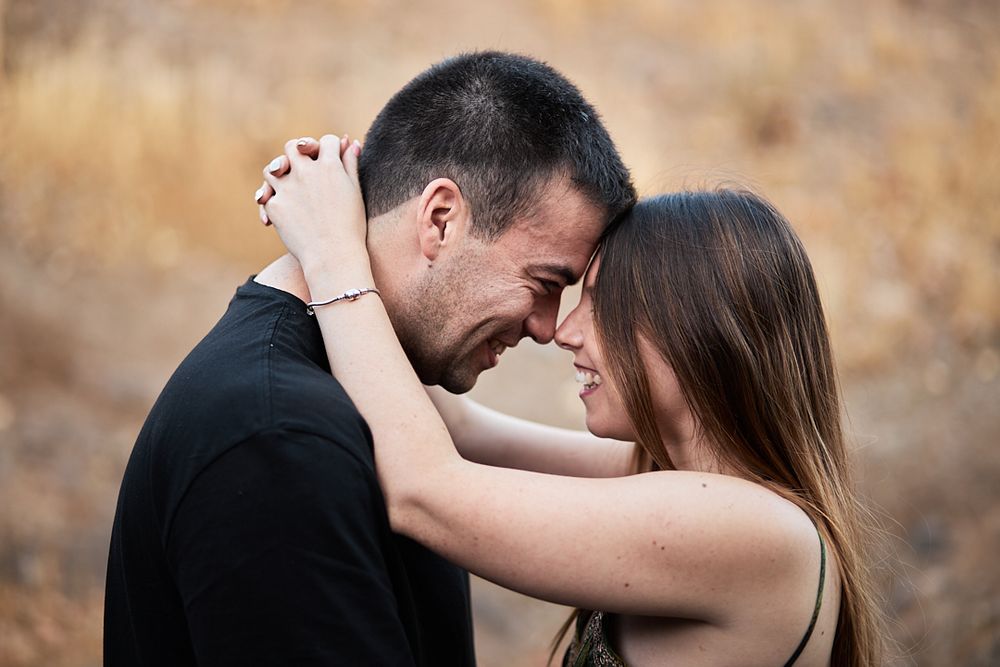 A tender moment between a couple embracing on a mountain road.
