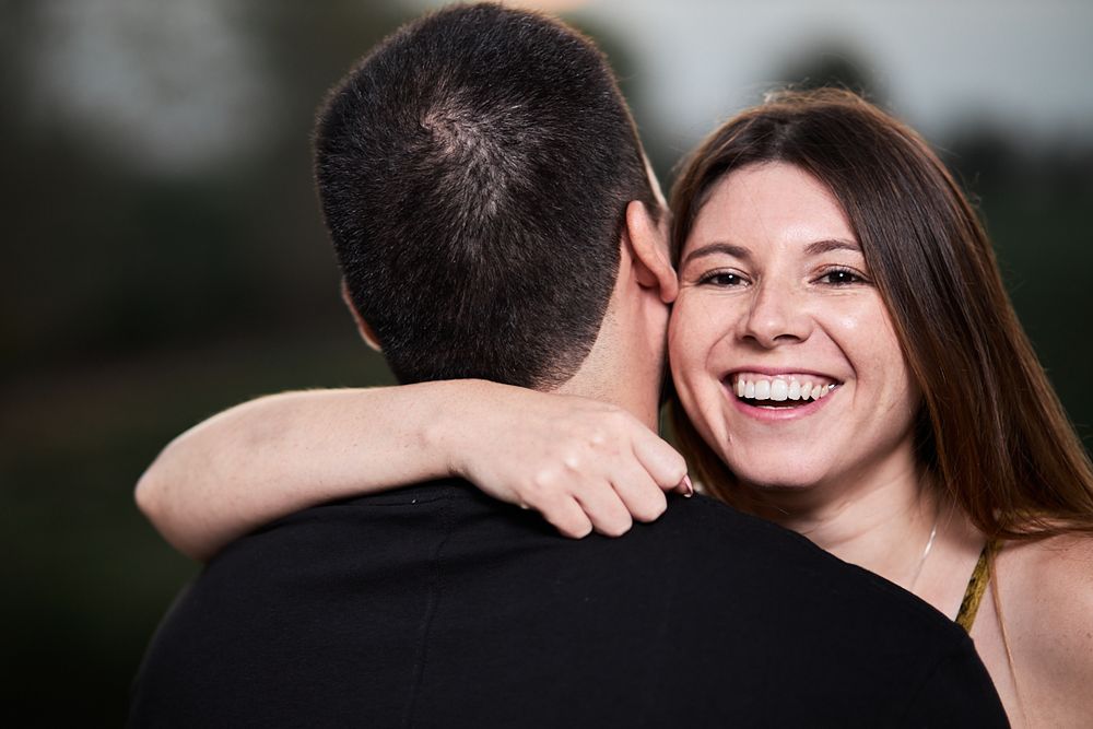 Happy couple sharing an intimate embrace outdoors with genuine laughter and joy.