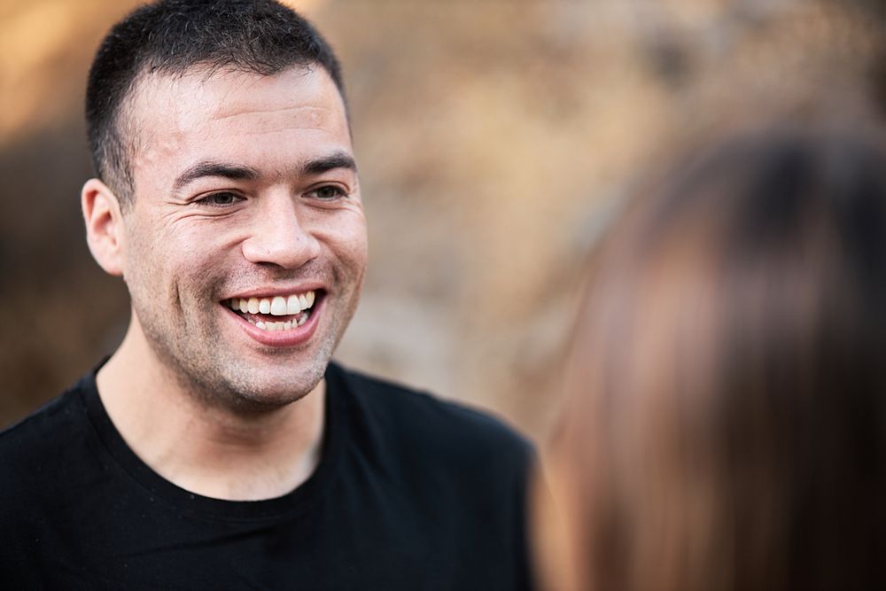 A candid portrait showing genuine laughter during an outdoor couples photoshoot.