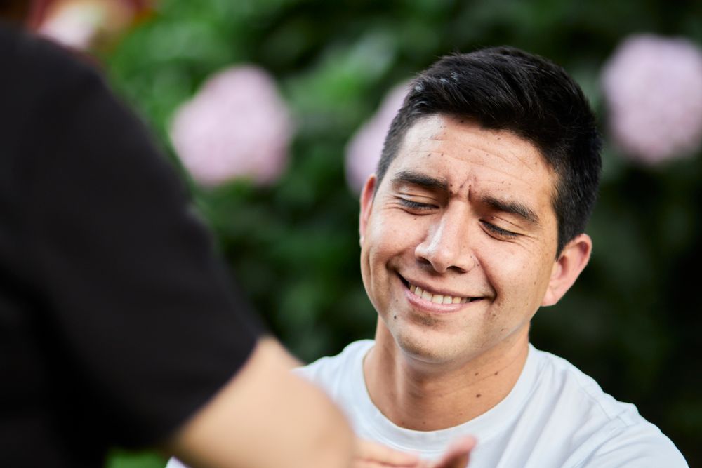 Close-up portrait of joyful laughter against a blurred garden background.
