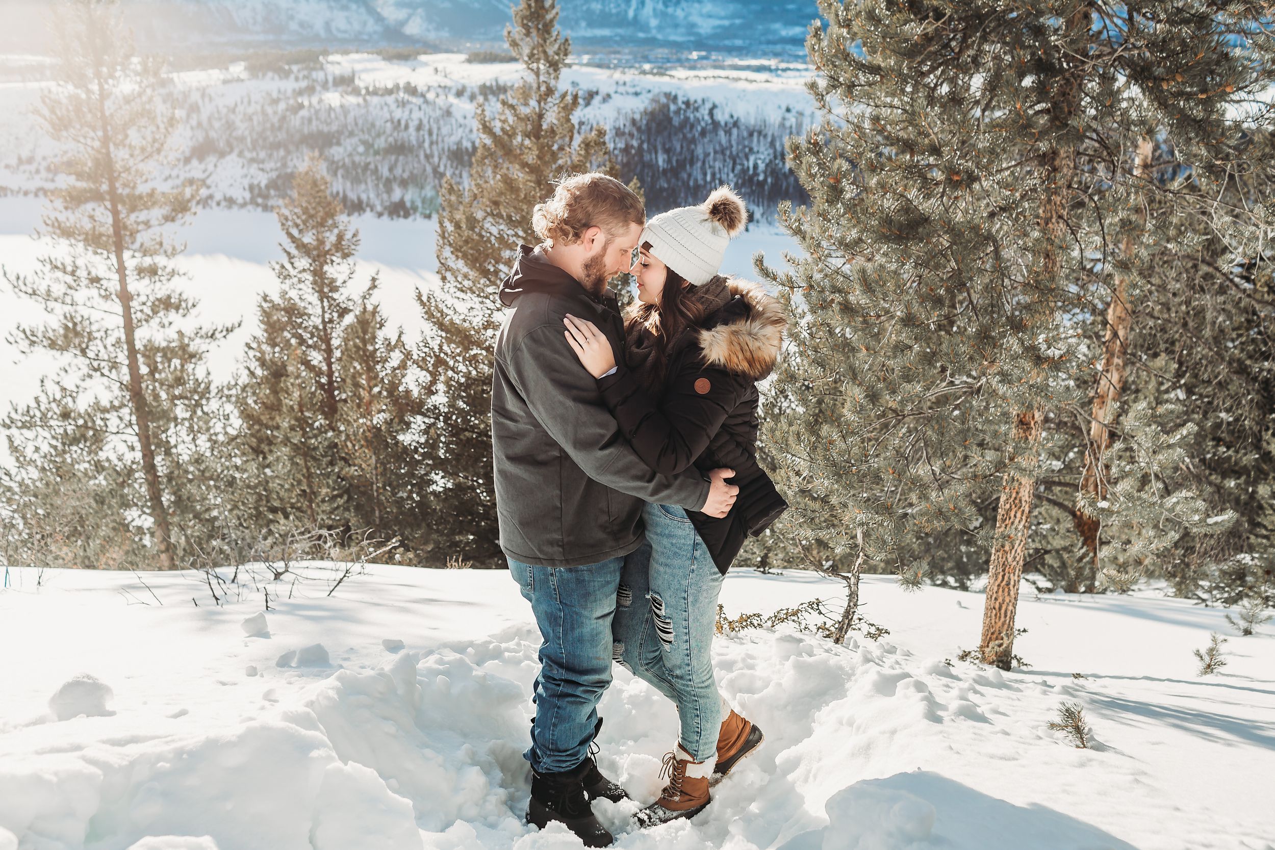 Couple holds one another for their engagement session in the mountains in Breckenridge CO.