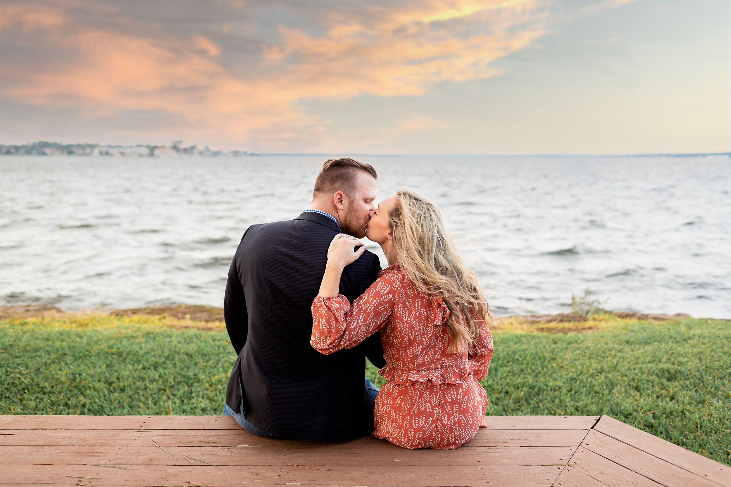 Couple kisses in front of Lake Conroe after getting engaged near Houston, TX.