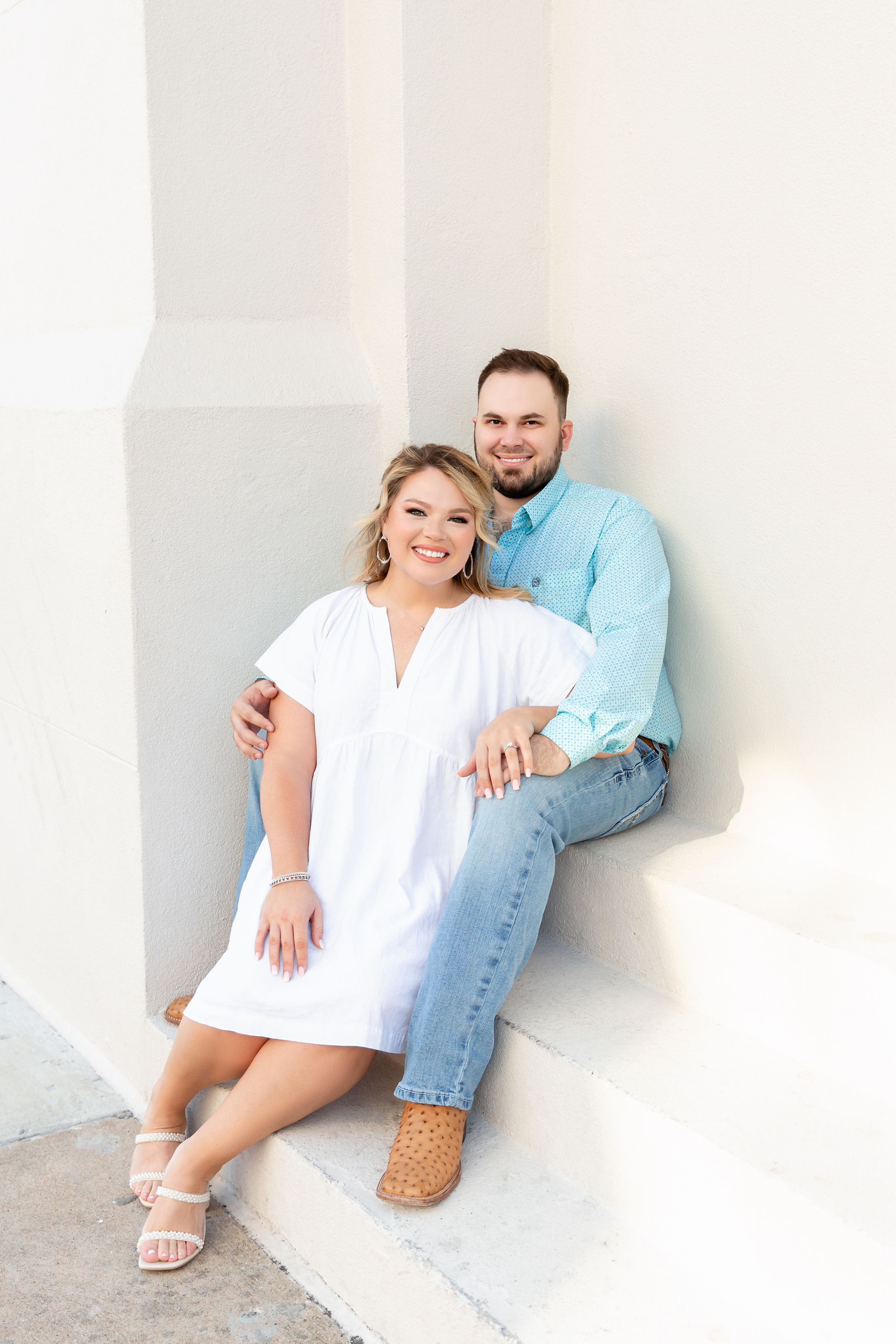 Couple gets close on the stairs for their engagement session in Galveston, TX.