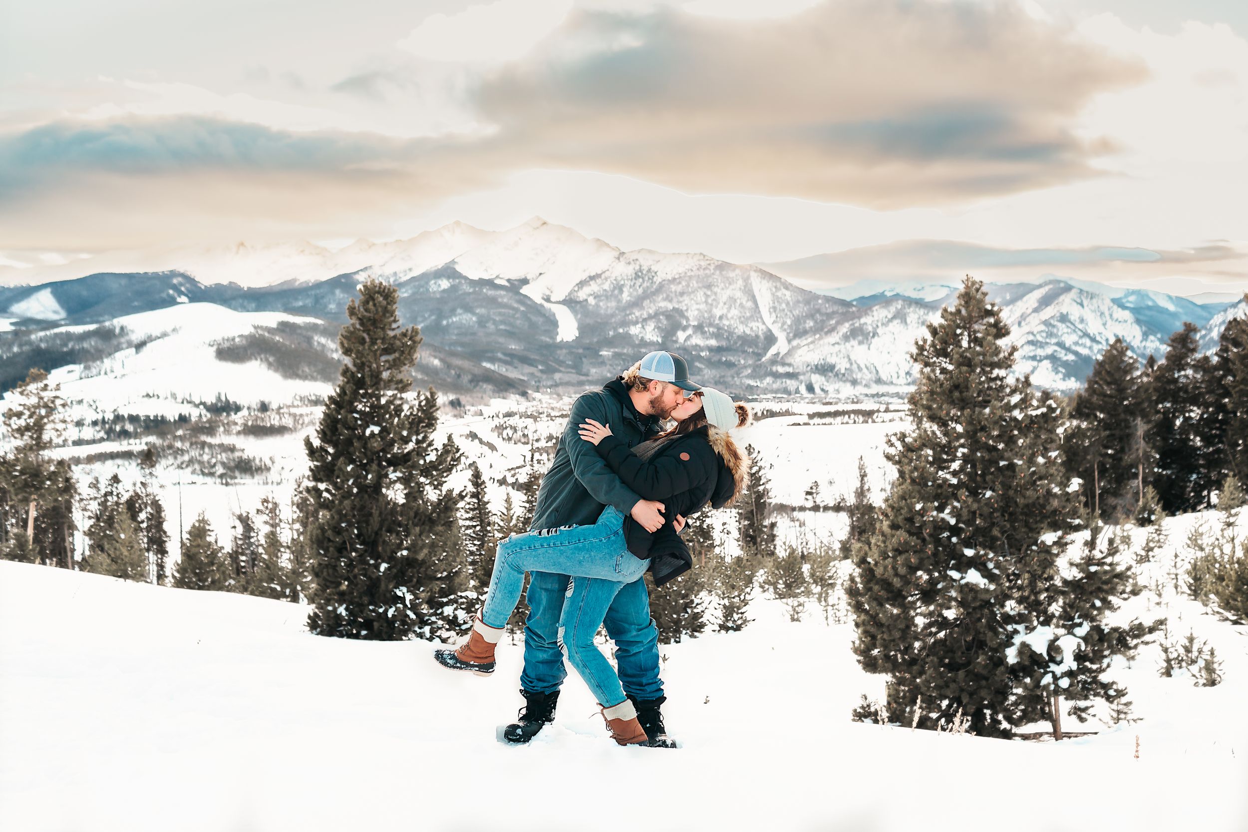 Couple does a dip during their engagement session in the mountains in Breckenridge, CO.
