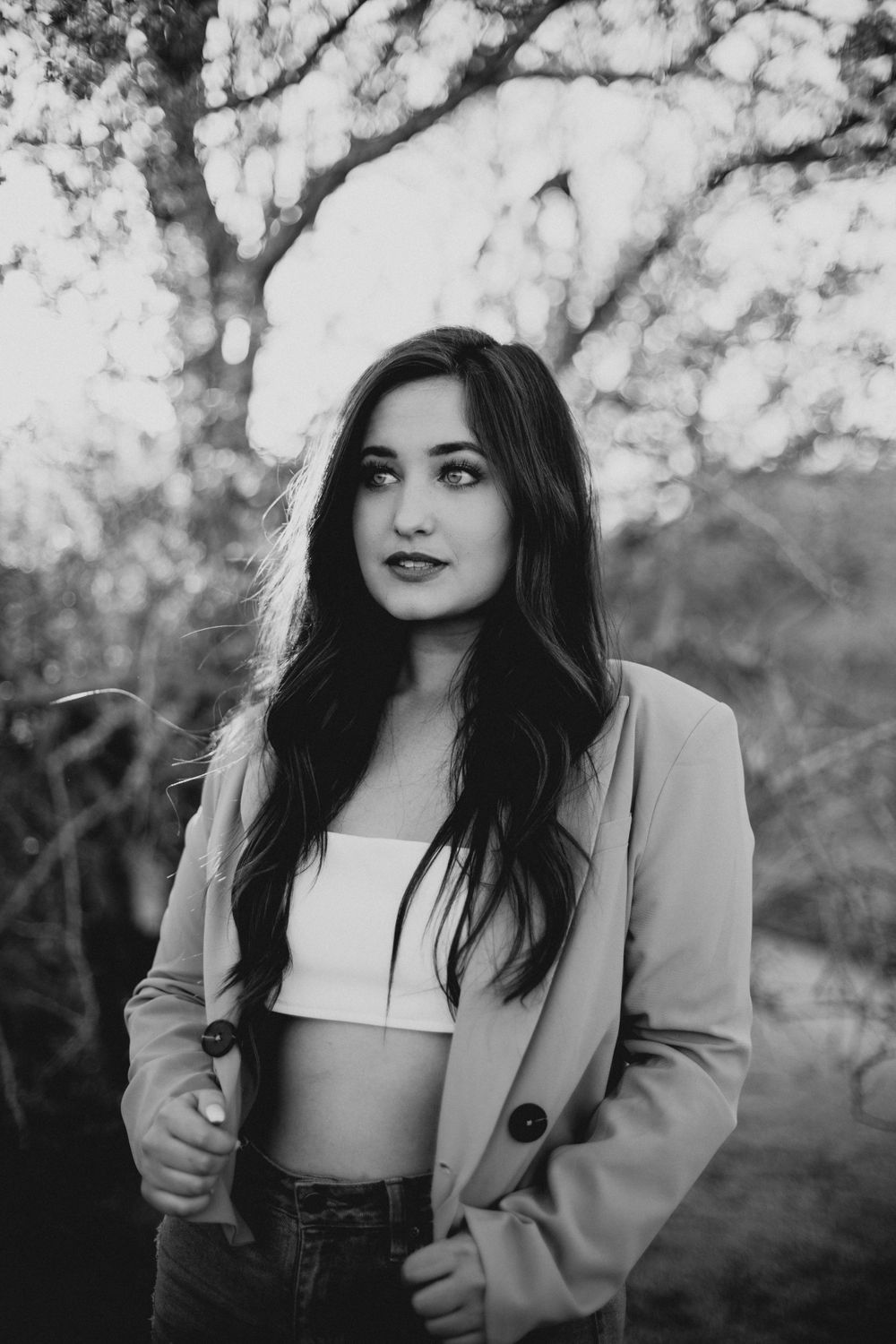 Black and white fashion portraits showing contemporary style with a blazer and crop top.