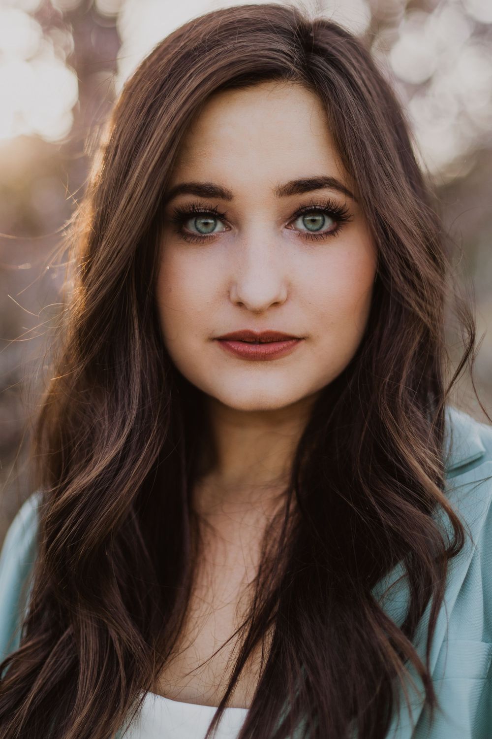 Portrait series showing different expressions with mint blazer and dark hair.