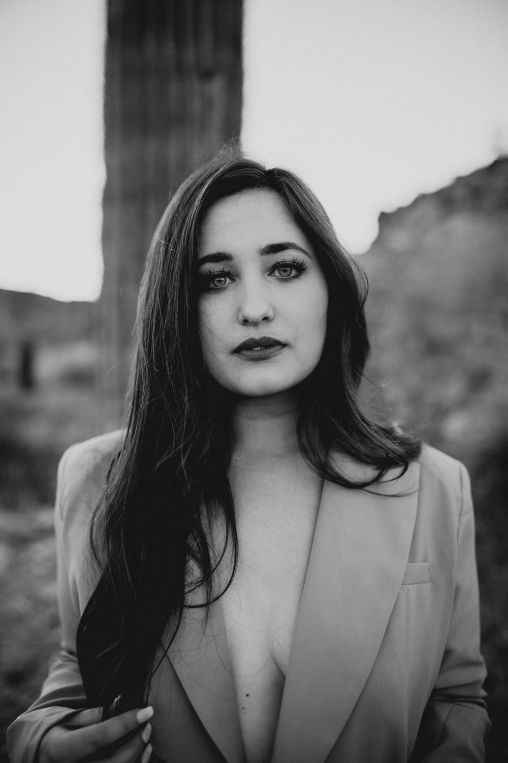 Black and white portrait series showing dramatic close-up poses in a blazer against a blurred background.