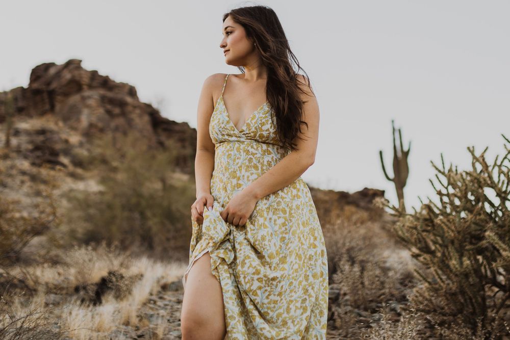 Fashion photography in desert setting with floral dress and natural desert flora.