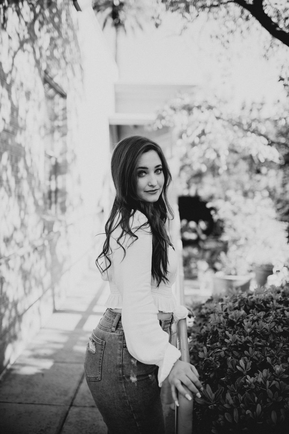 Black and white portrait series in a garden setting with natural lighting.