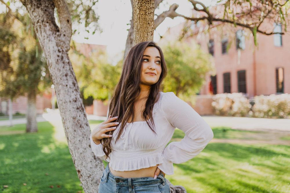 Casual spring portraits in a garden setting with blooming trees and sunlight.