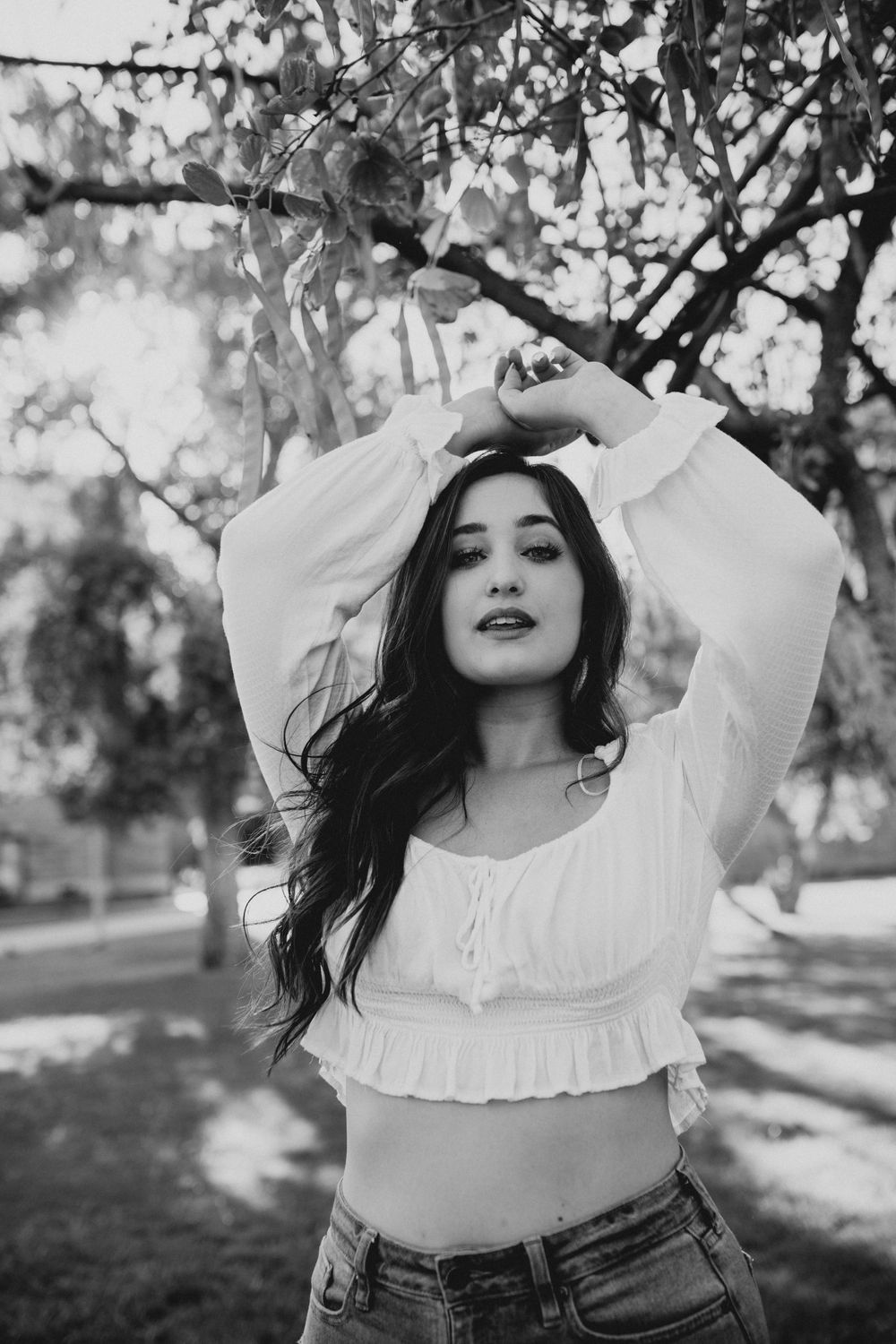 Black and white portraits showing dynamic poses under tree branches in natural lighting.