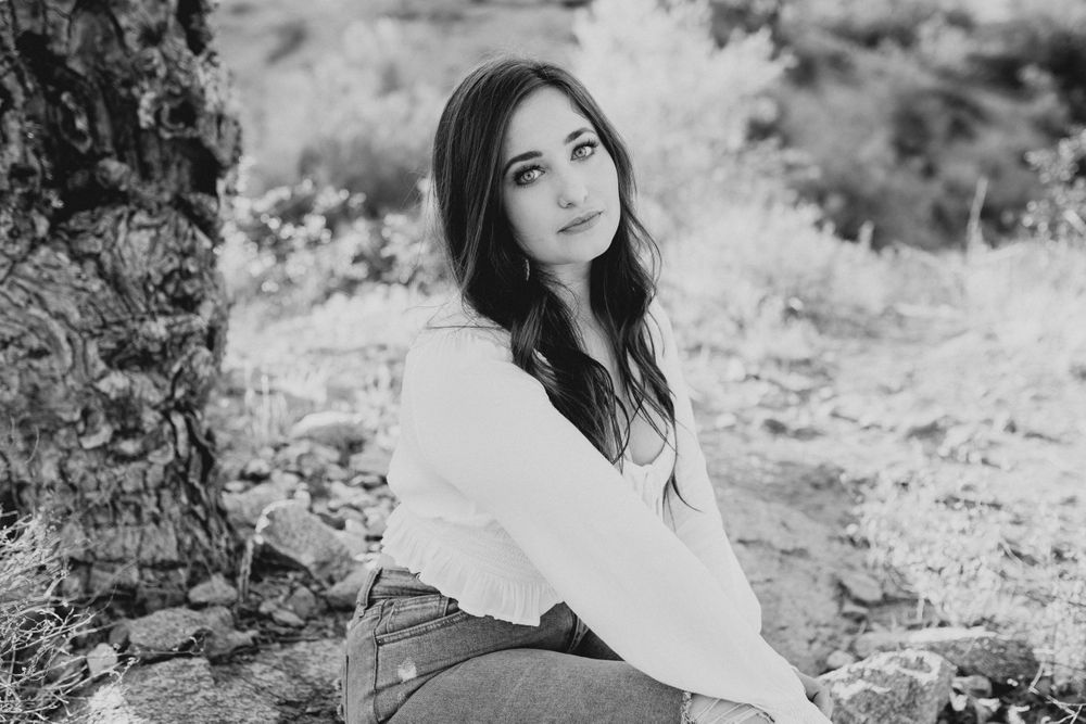 Black and white portrait series capturing natural smiles and expressions in an outdoor setting.