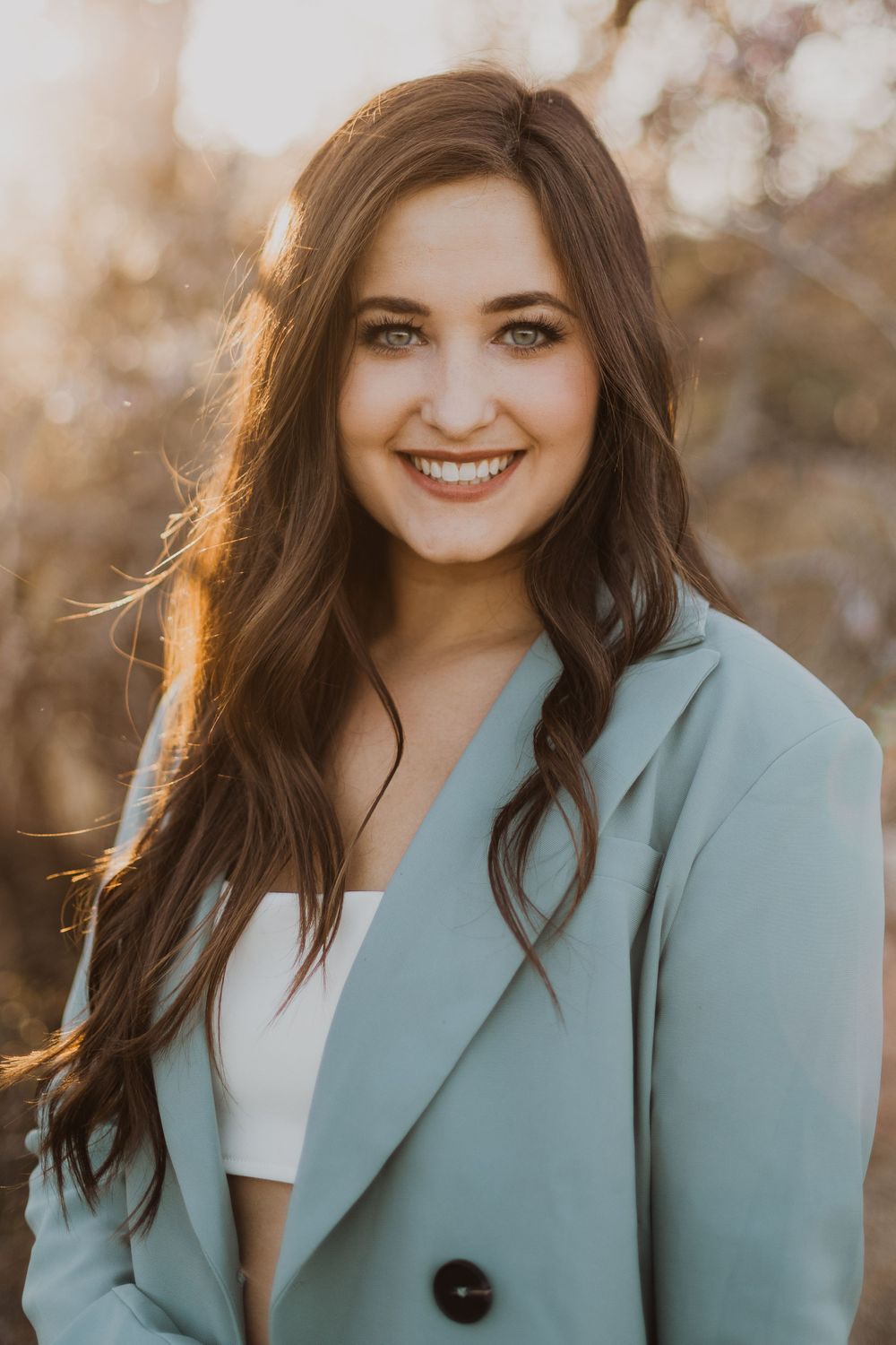 Fashion portraits showing someone wearing a stylish mint blazer with natural sunset lighting.
