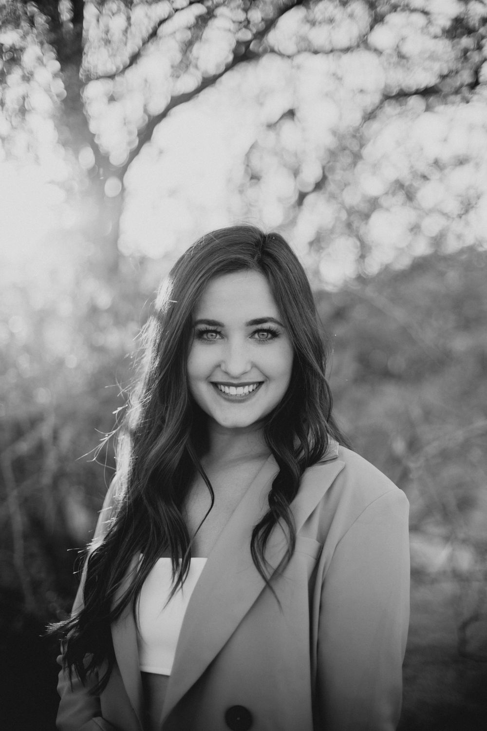 Black and white portraits capturing genuine smiles and expressions with bokeh background effects.
