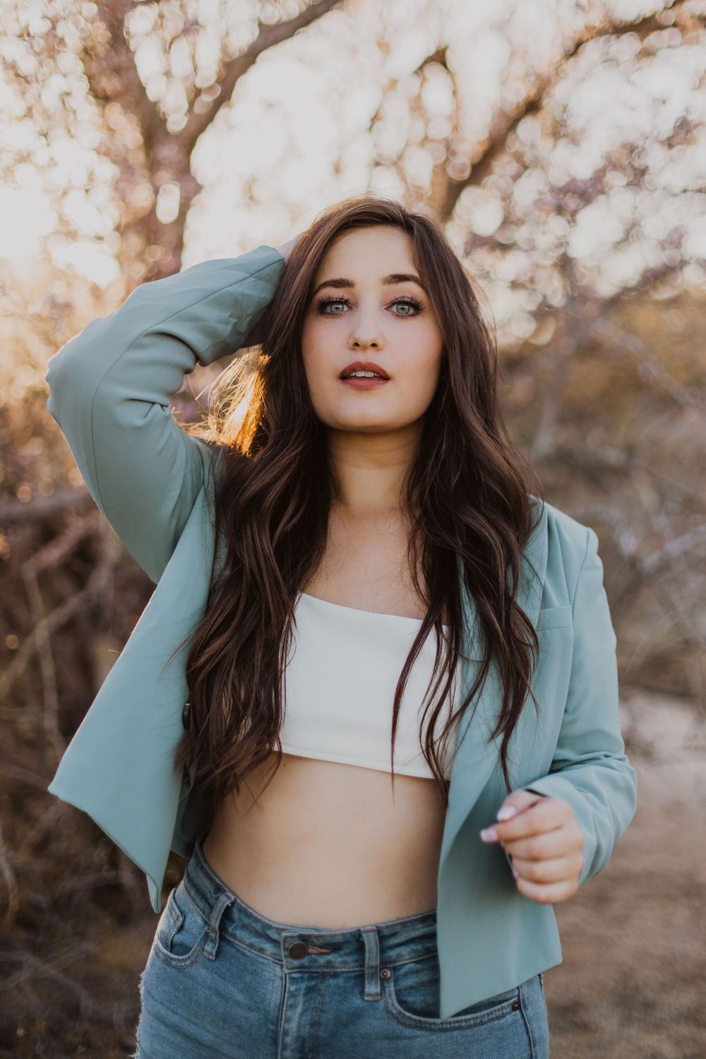 Stylish outdoor photoshoot combining casual denim with a structured mint blazer.