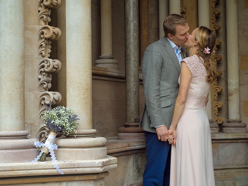 Romantic wedding photography a couple hold hands in alcove at St Albans Cathedral, Hertfordshire.