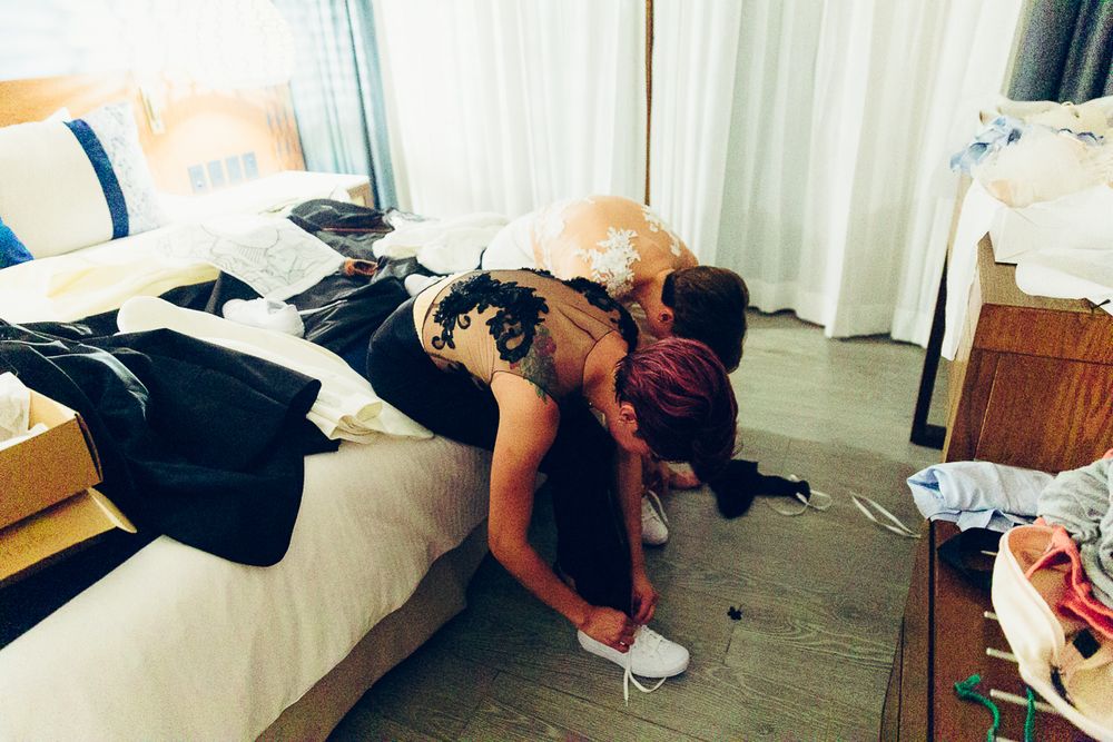 Getting ready scene with formal attire scattered across a hotel room bed.