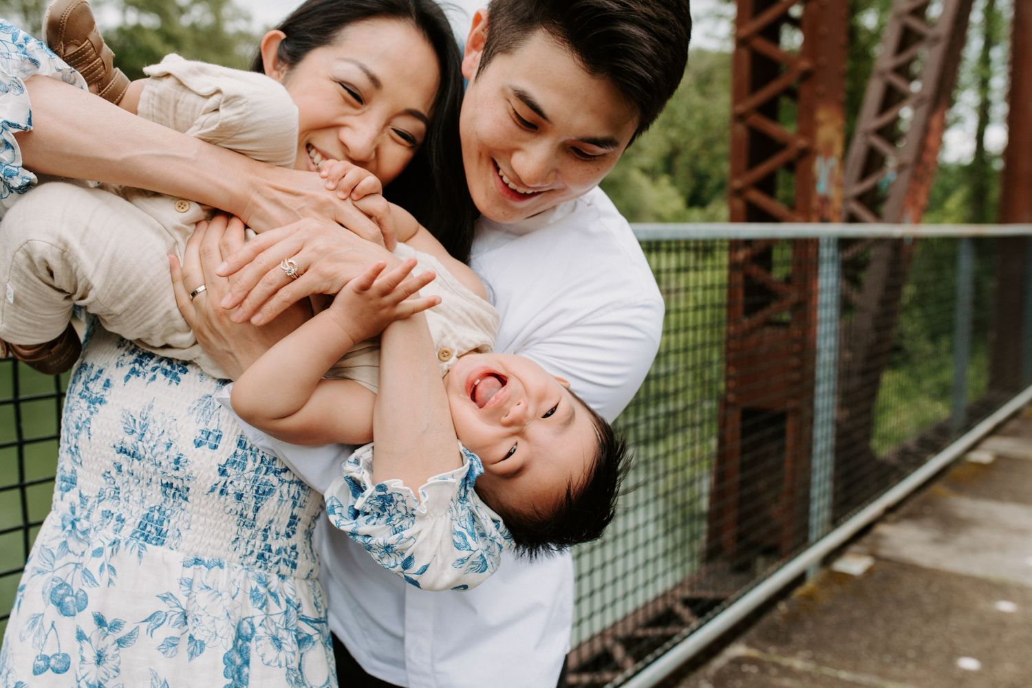 Joyful family moments captured against fence in outdoor setting.