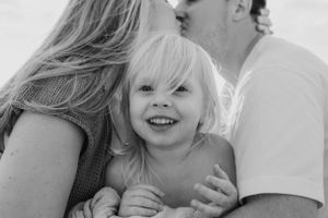 Black and white candid family moment capturing joy and laughter.