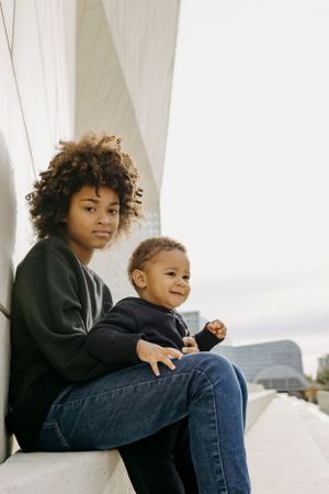 A relaxed moment on concrete steps with an urban backdrop.