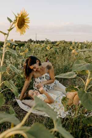 Mother and child sharing a sweet moment in a blooming sunflower field.